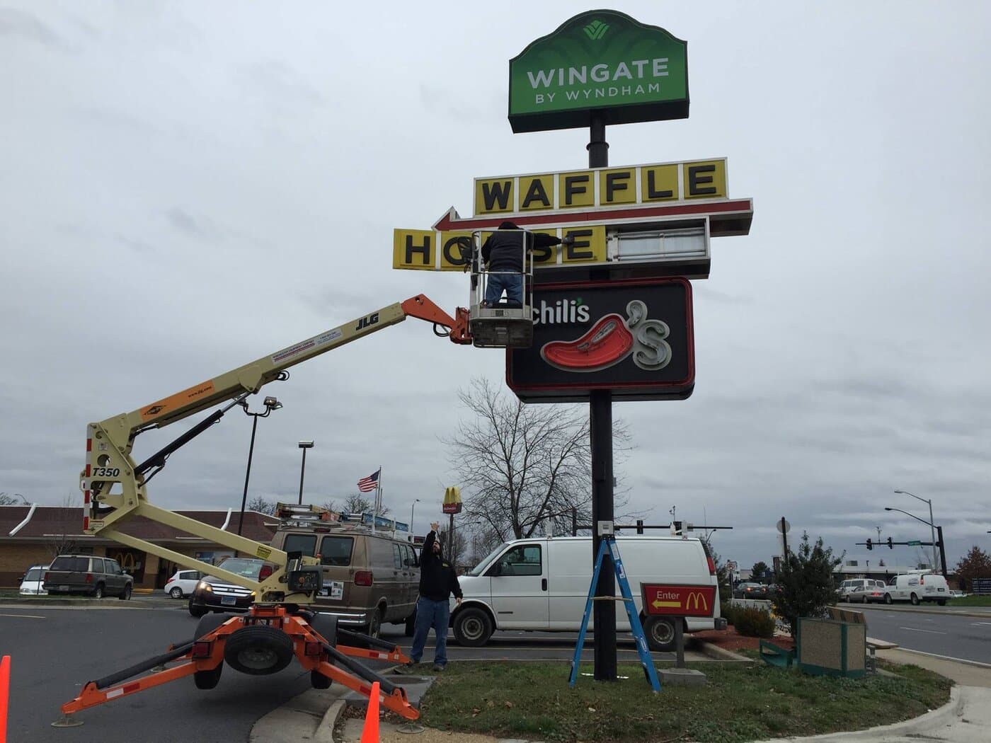 Sign technicians on a lift servicing commercial signs at a Frederick County intersection
